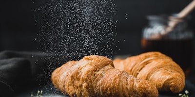 Assortment of fresh French pastries on marble counter, croissants, pain au chocolat, macarons, morning light, bakery display, professional food photography
